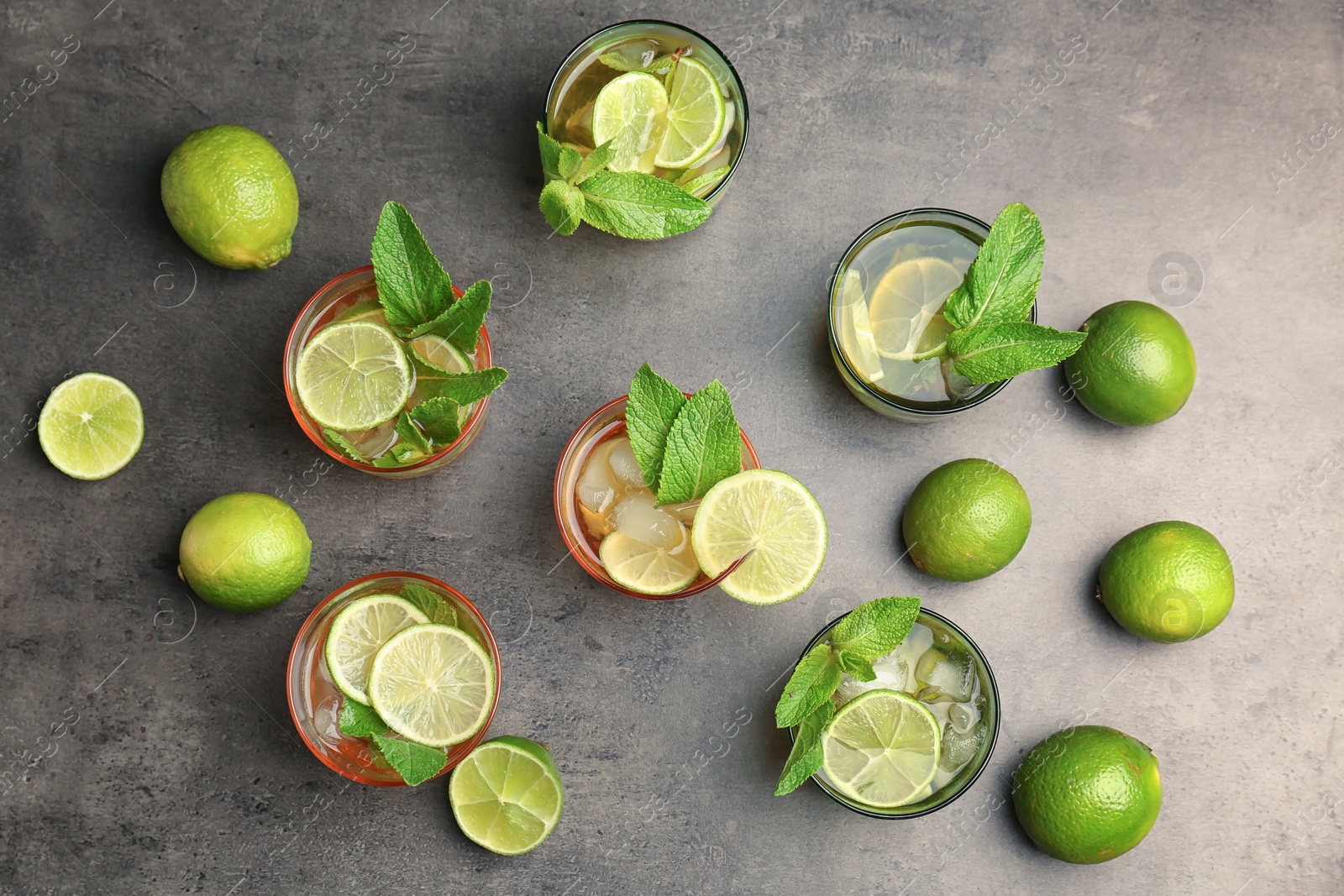 Photo of Flat lay composition with mint julep cocktail in glasses on grey background