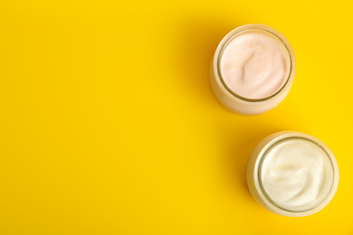 Photo of Tasty organic yogurt on yellow background, flat lay. Space for text