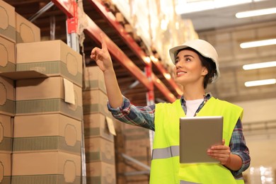 Image of Woman with tablet working at warehouse. Logistics center
