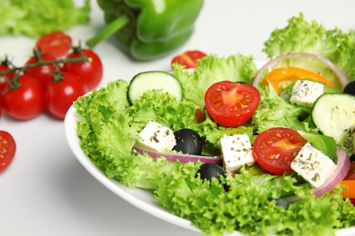 Tasty fresh Greek salad on white table, closeup