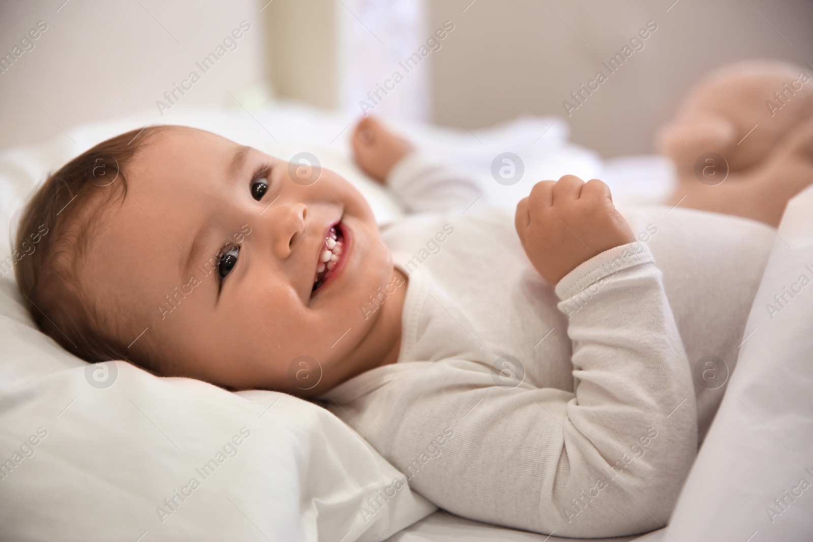 Photo of Cute little baby lying in comfortable crib. Bedtime