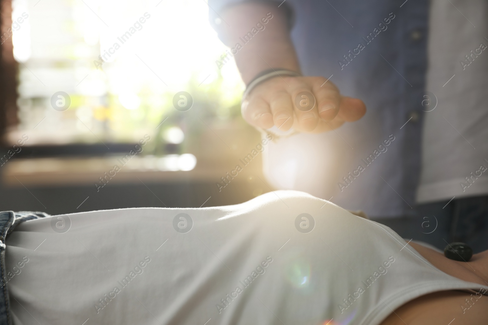 Photo of Young woman during crystal healing session in therapy room, closeup