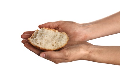 Photo of Poor woman holding piece of bread on white background, closeup