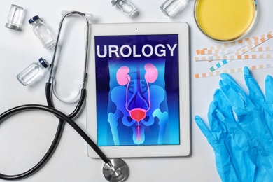 Photo of Flat lay composition with tablet, stethoscope and urine in dish on light background. Urology concept