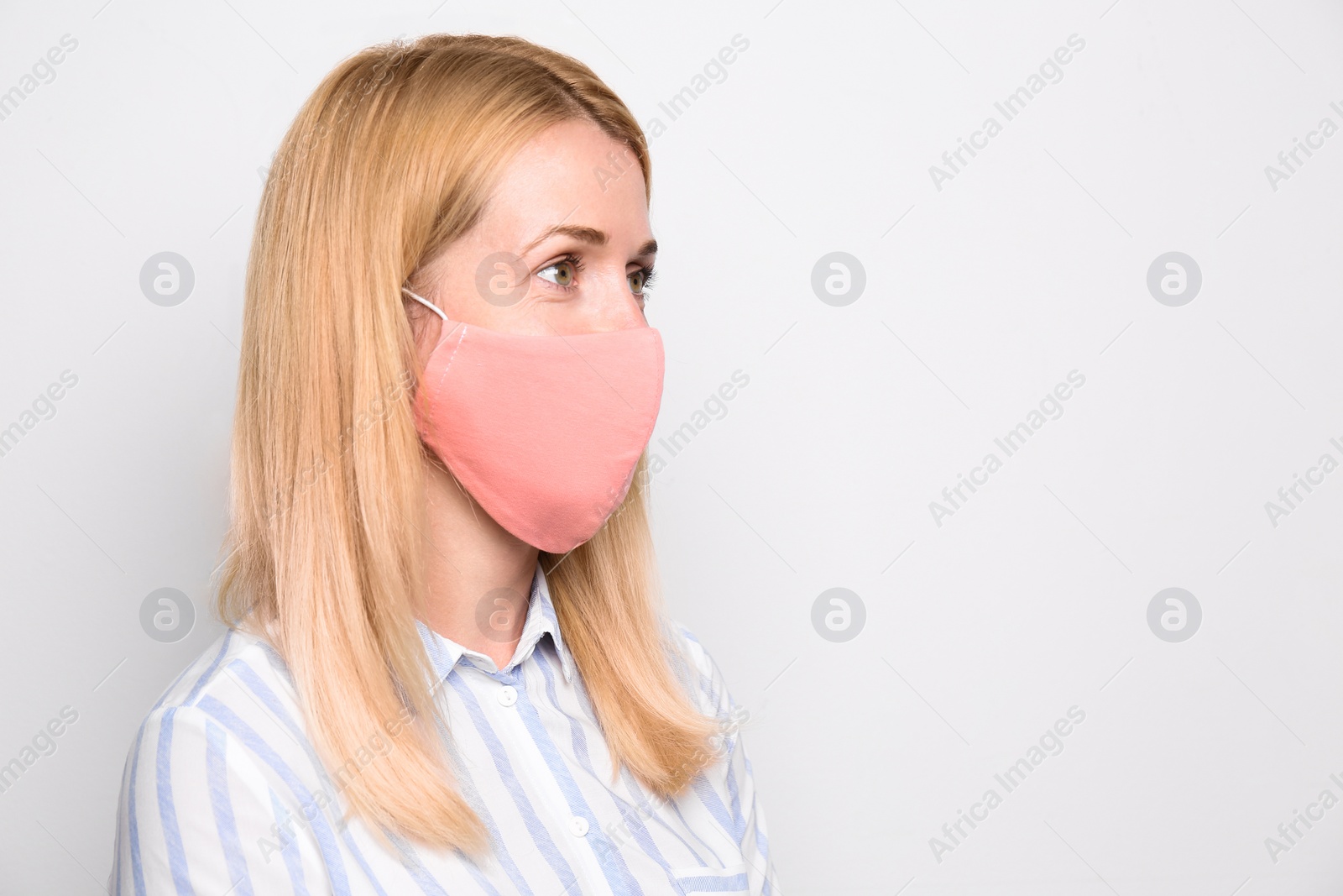 Photo of Woman wearing handmade cloth mask on white background, space for text. Personal protective equipment during COVID-19 pandemic