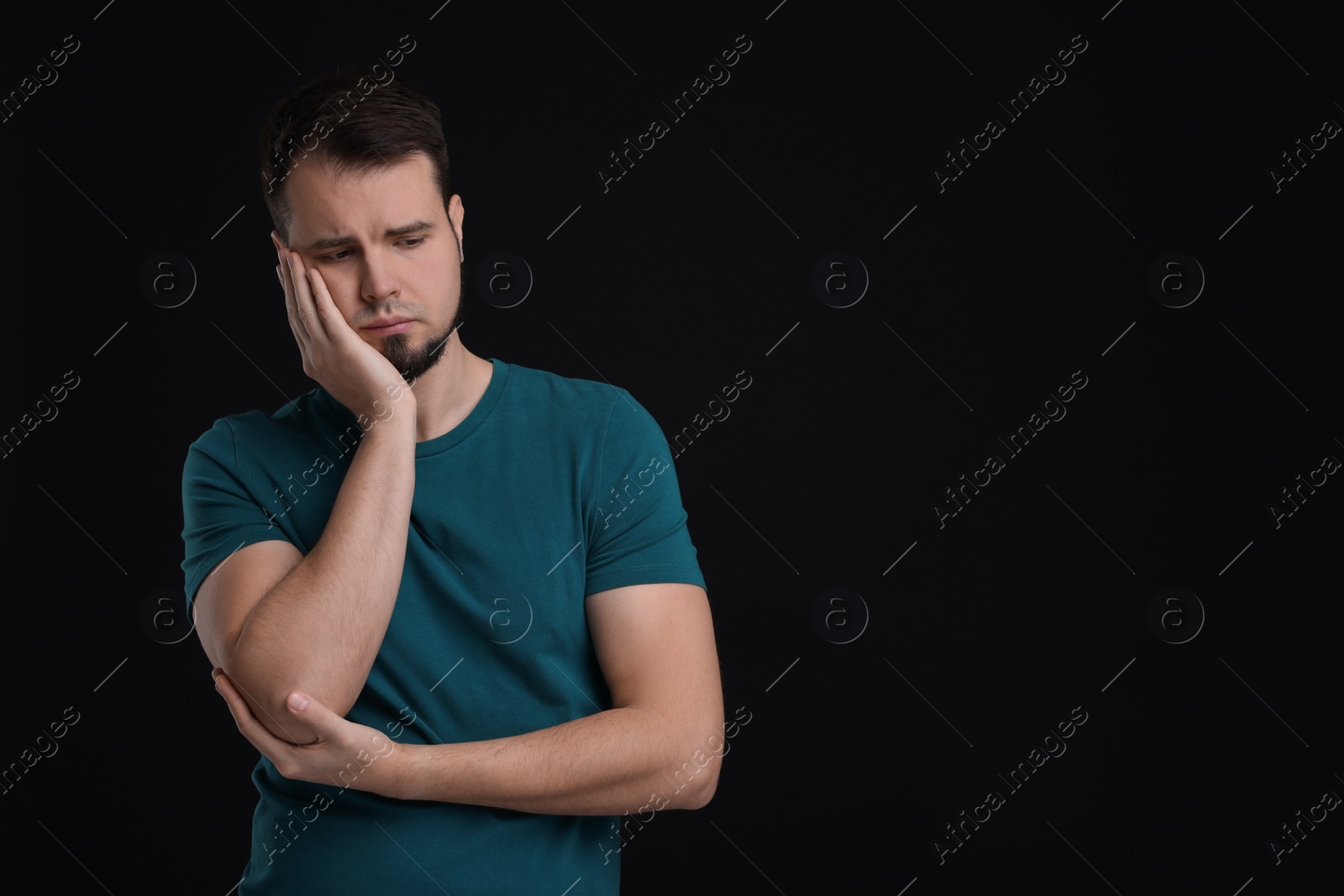 Photo of Portrait of sad man on black background, space for text