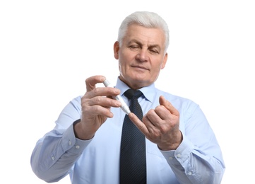 Photo of Senior man using lancet pen on white background. Diabetes control