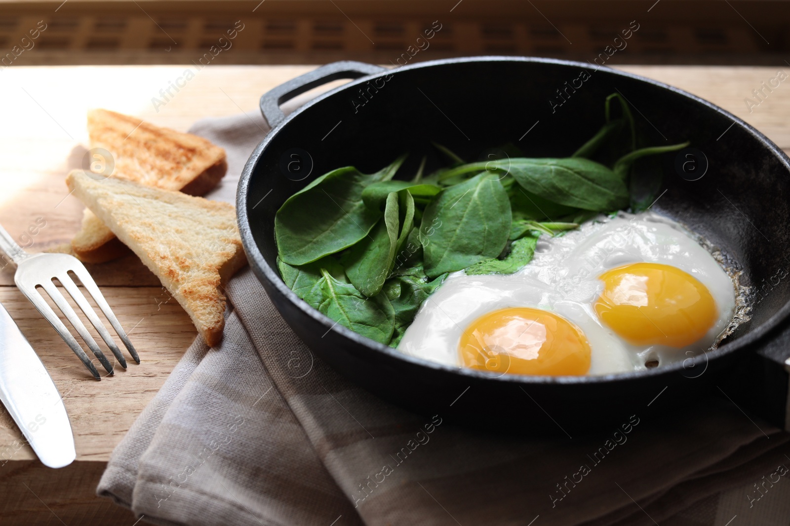 Photo of Delicious fried egg with spinach served on wooden table