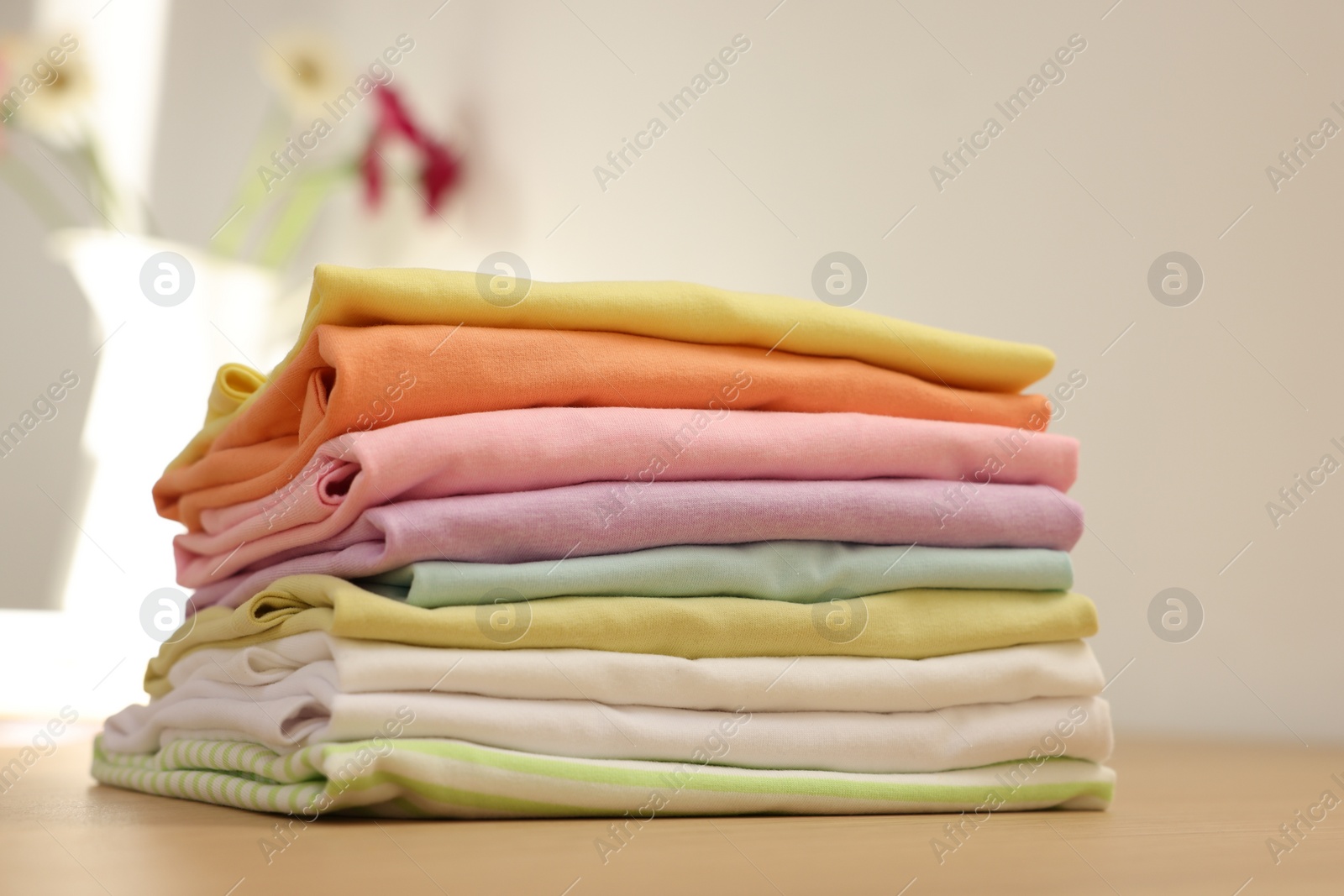 Photo of Stack of clean clothes on wooden table