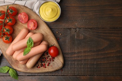 Photo of Delicious boiled sausages, sauce, tomatoes and spices on wooden table, flat lay. Space for text