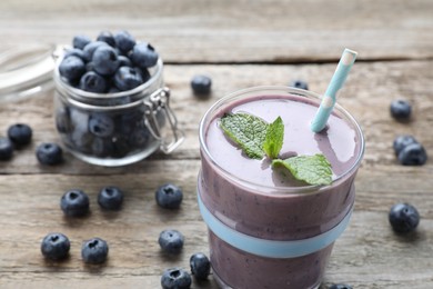 Photo of Freshly made blueberry smoothie on wooden table, closeup. Space for text