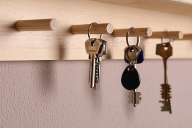 Photo of Wooden hanger for keys on color wall, closeup