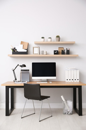 Photo of Modern computer on table in office interior. Stylish workplace