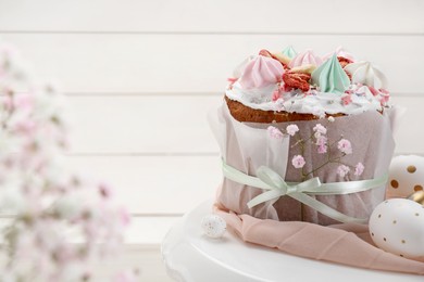 Photo of Traditional Easter cake with meringues and painted eggs on stand, space for text