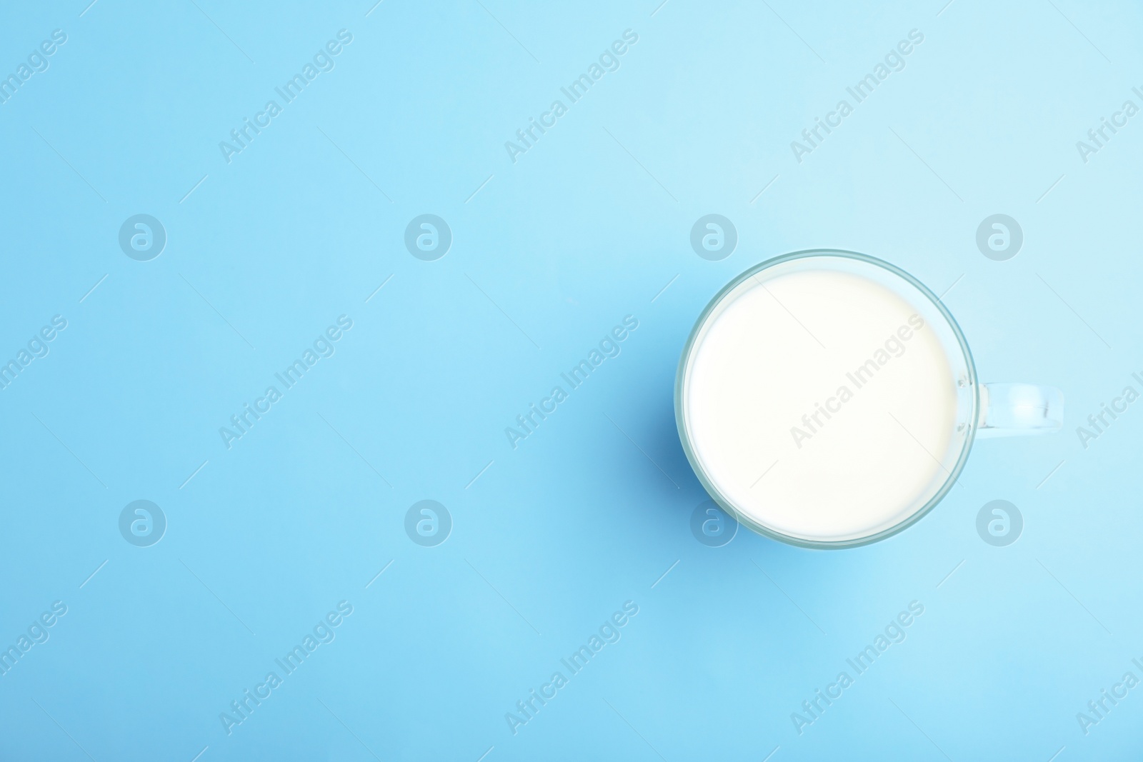 Photo of Cup of fresh milk on color background, top view. Space for text