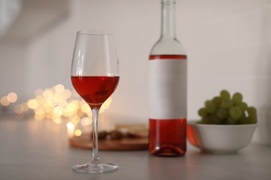 Photo of Glass of delicious wine on table, space for text. Bokeh effect