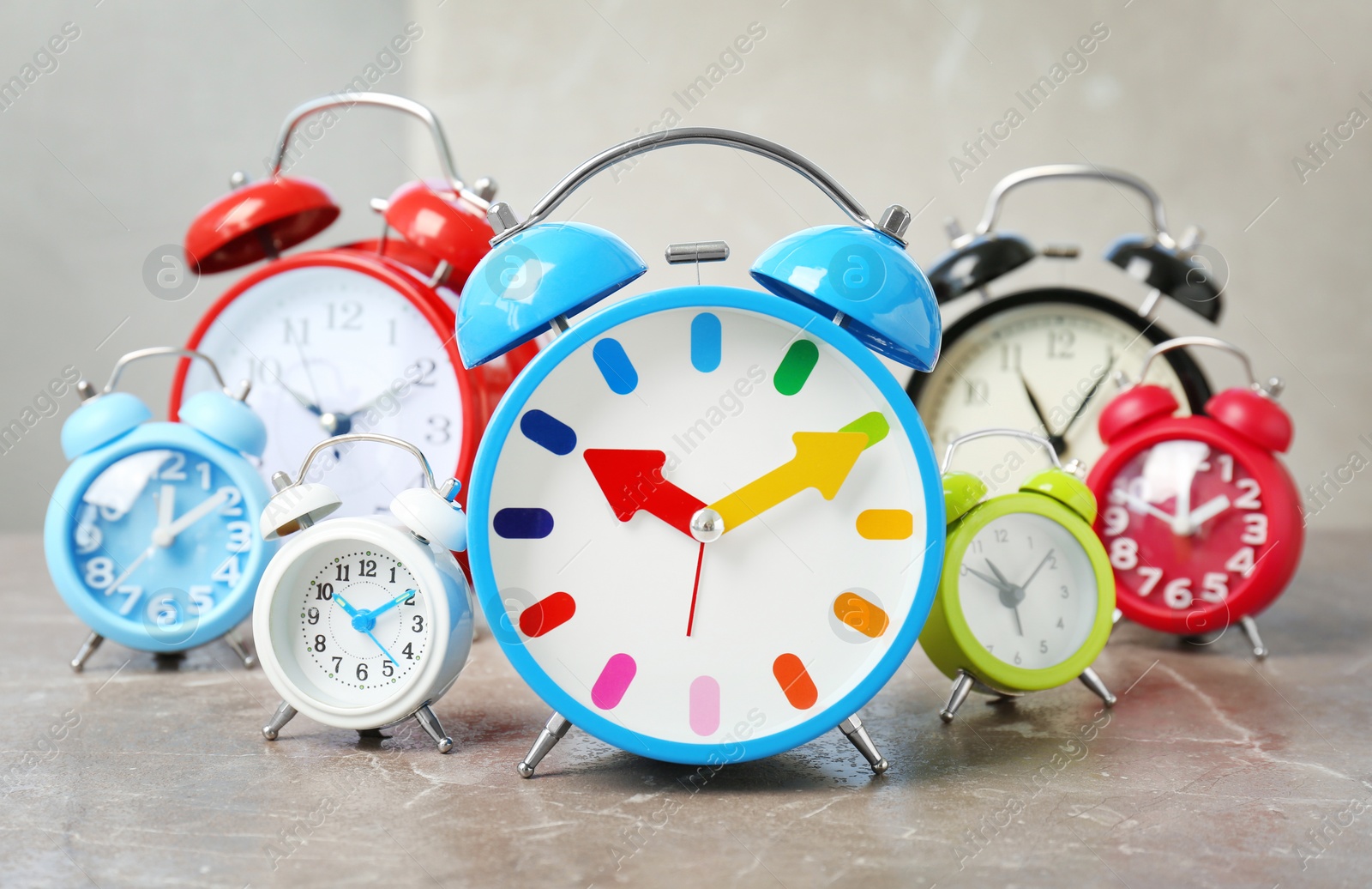 Photo of Many different alarm clocks on table. Time change concept