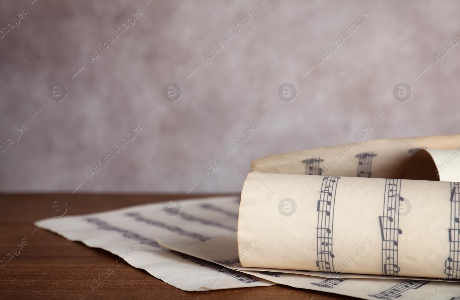 Photo of Music sheets with notes on table against color background, closeup. Space for text