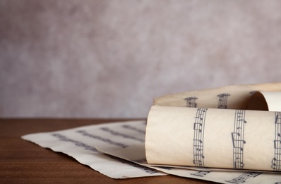 Music sheets with notes on table against color background, closeup. Space for text