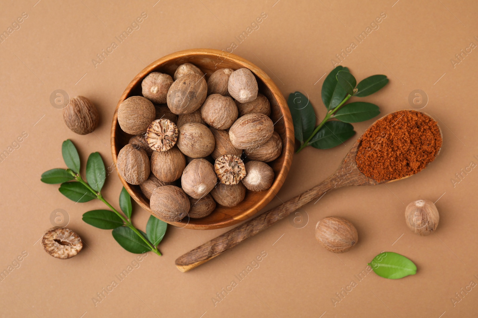 Photo of Flat lay composition with nutmegs on light brown background