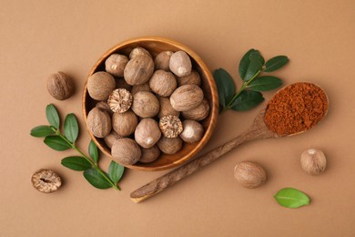 Flat lay composition with nutmegs on light brown background