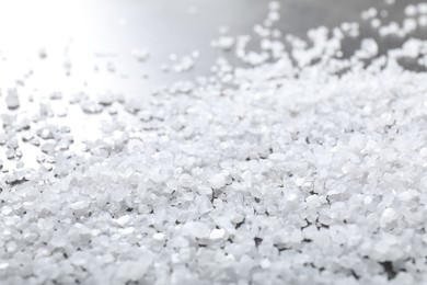 Photo of Scattered white natural salt on table, closeup