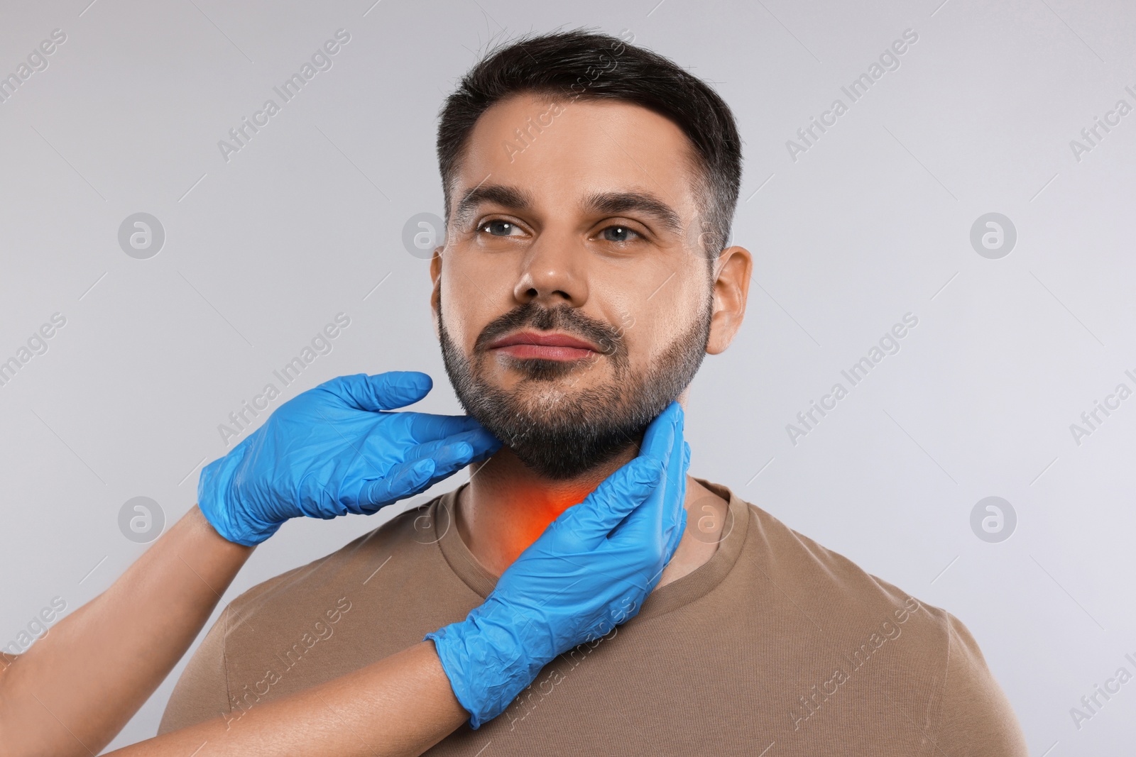 Image of Endocrinologist examining thyroid gland of patient on light grey background, closeup