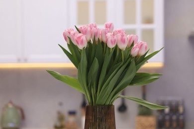 Beautiful bouquet of fresh pink tulips in kitchen