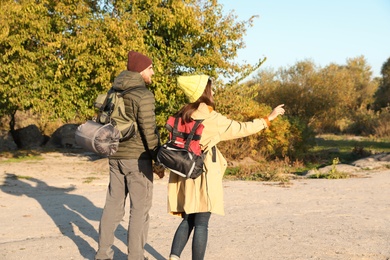 Couple of campers with backpacks and sleeping bags in wilderness