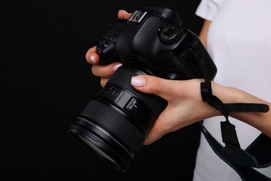 Photo of Photographer with camera on black background, closeup