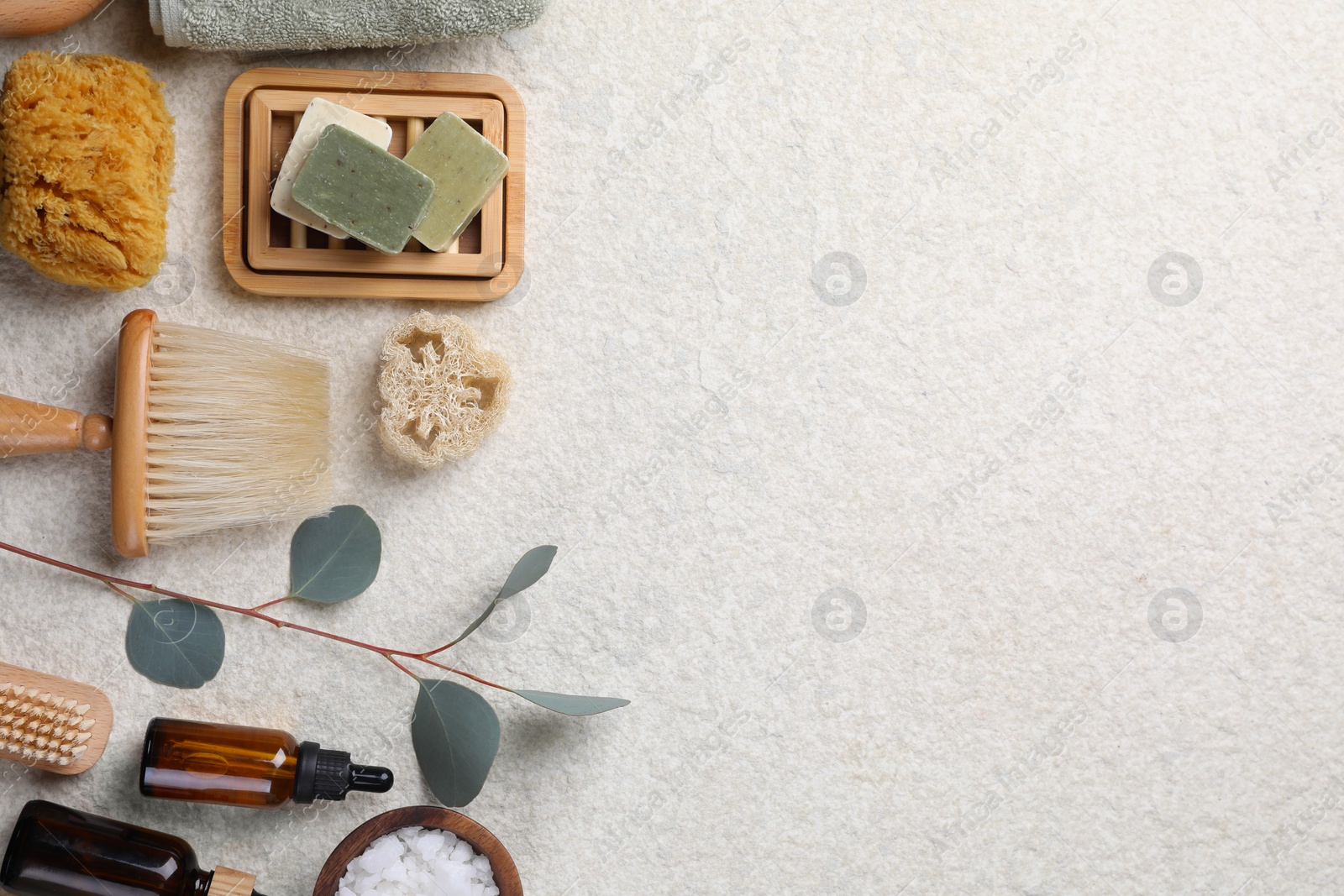 Photo of Flat lay composition with different spa products and eucalyptus branch on light grey textured table. Space for text