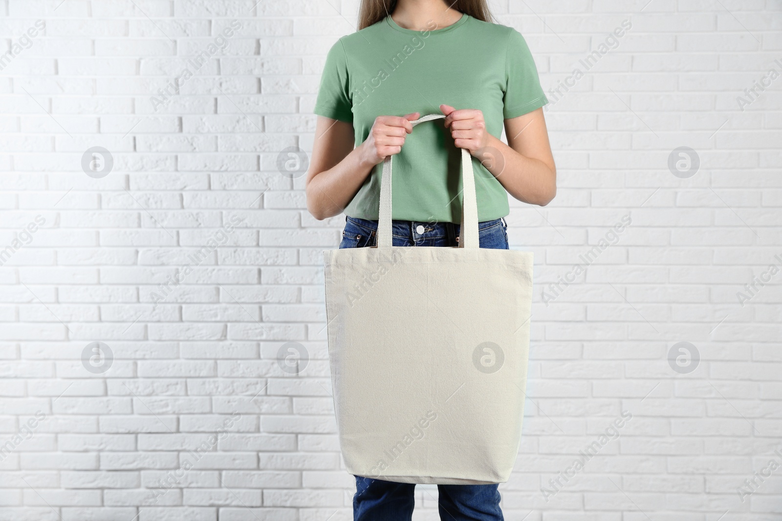 Photo of Woman with eco bag near brick wall. Mock up for design