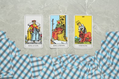 Photo of Tarot cards on light grey marble table, flat lay