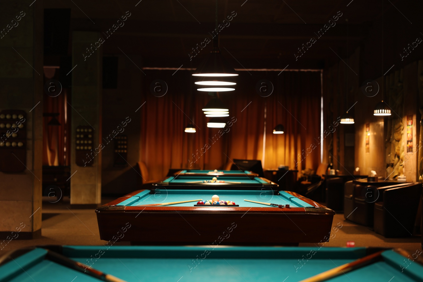 Photo of Billiard tables with balls and cues in club