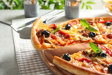 Slice of tasty pizza with olives and sausages on shovel, closeup