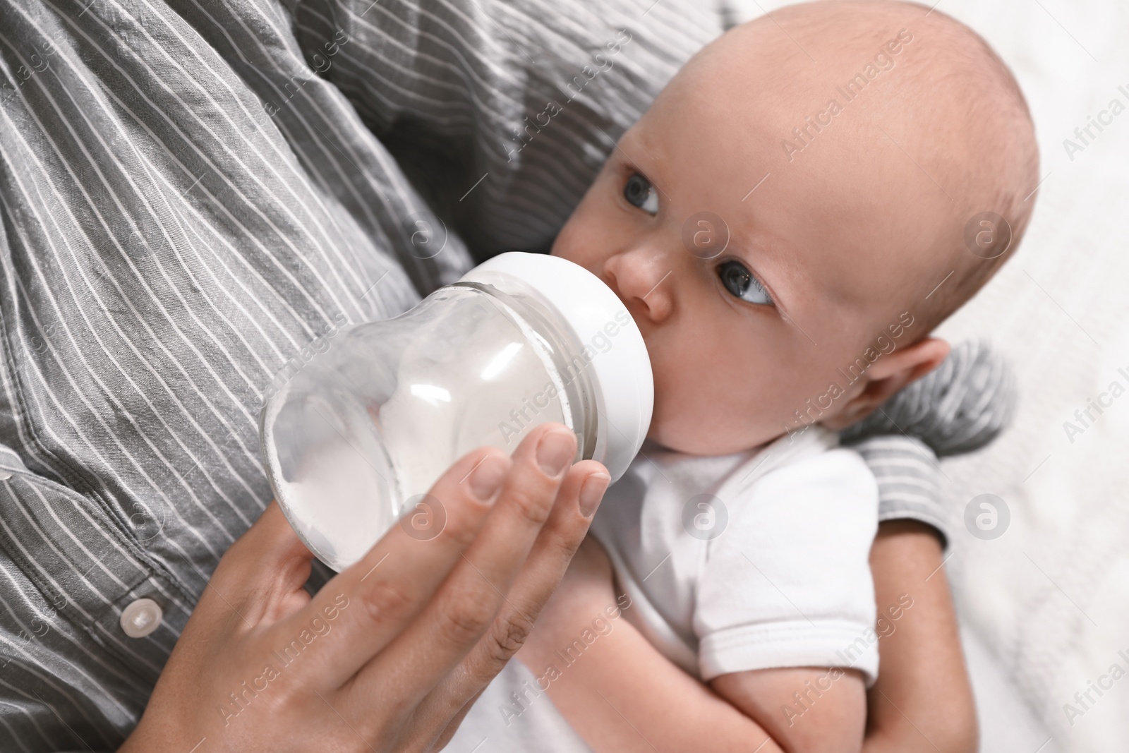 Photo of Mother feeding her little baby from bottle, closeup