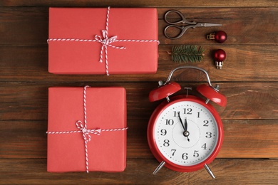 Flat lay composition with Christmas gifts and alarm clock on wooden table. Boxing day