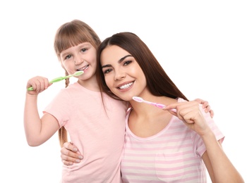 Photo of Little girl and her mother brushing teeth together on white background