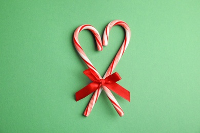 Photo of Candy canes on green background, flat lay