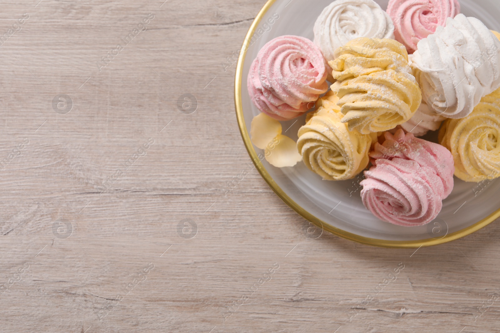 Photo of Plate with delicious marshmallows on wooden table, top view. Space for text