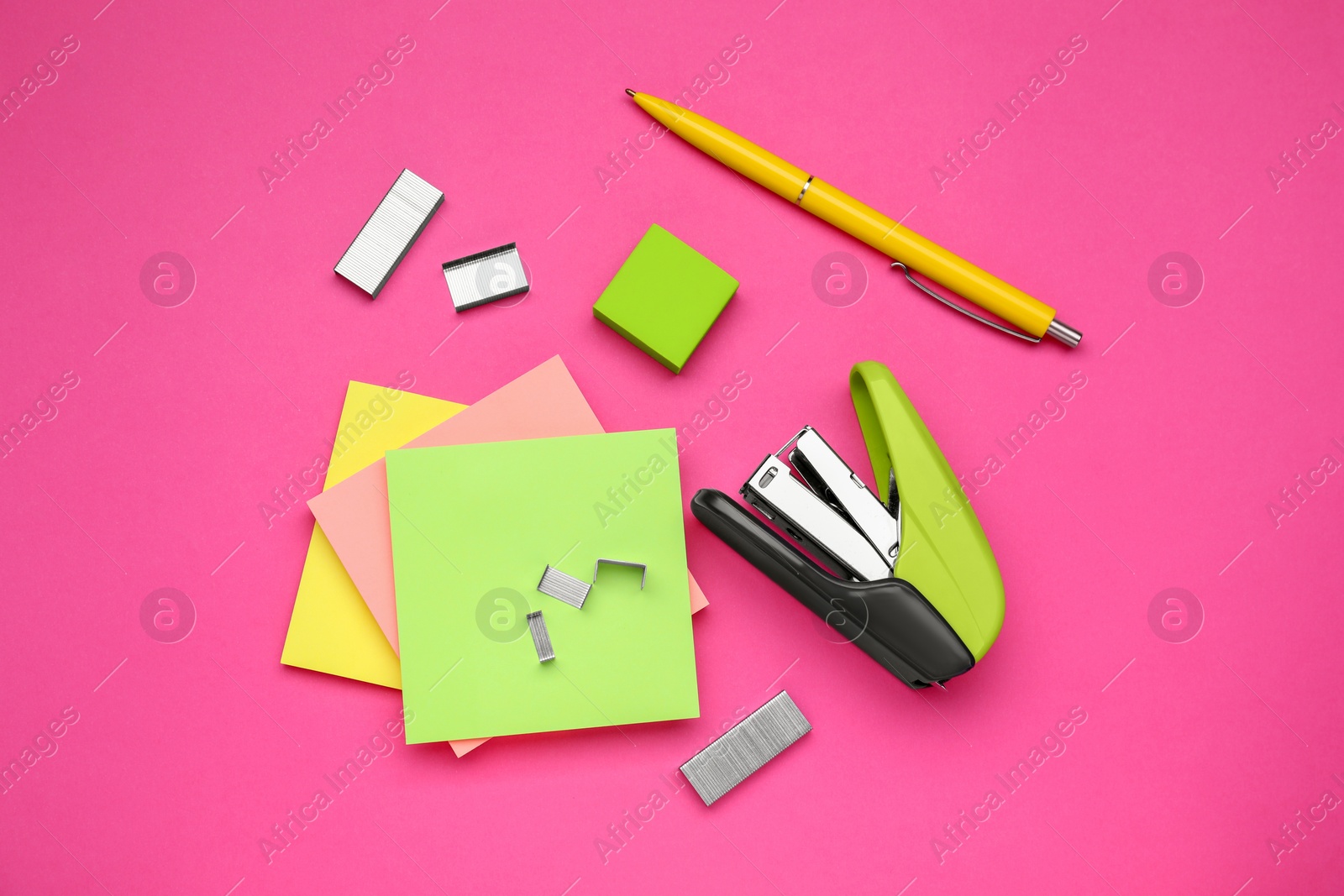 Photo of Flat lay composition with new stapler on pink background