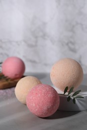 Photo of Beautiful aromatic bath bombs and green twig on grey table, space for text