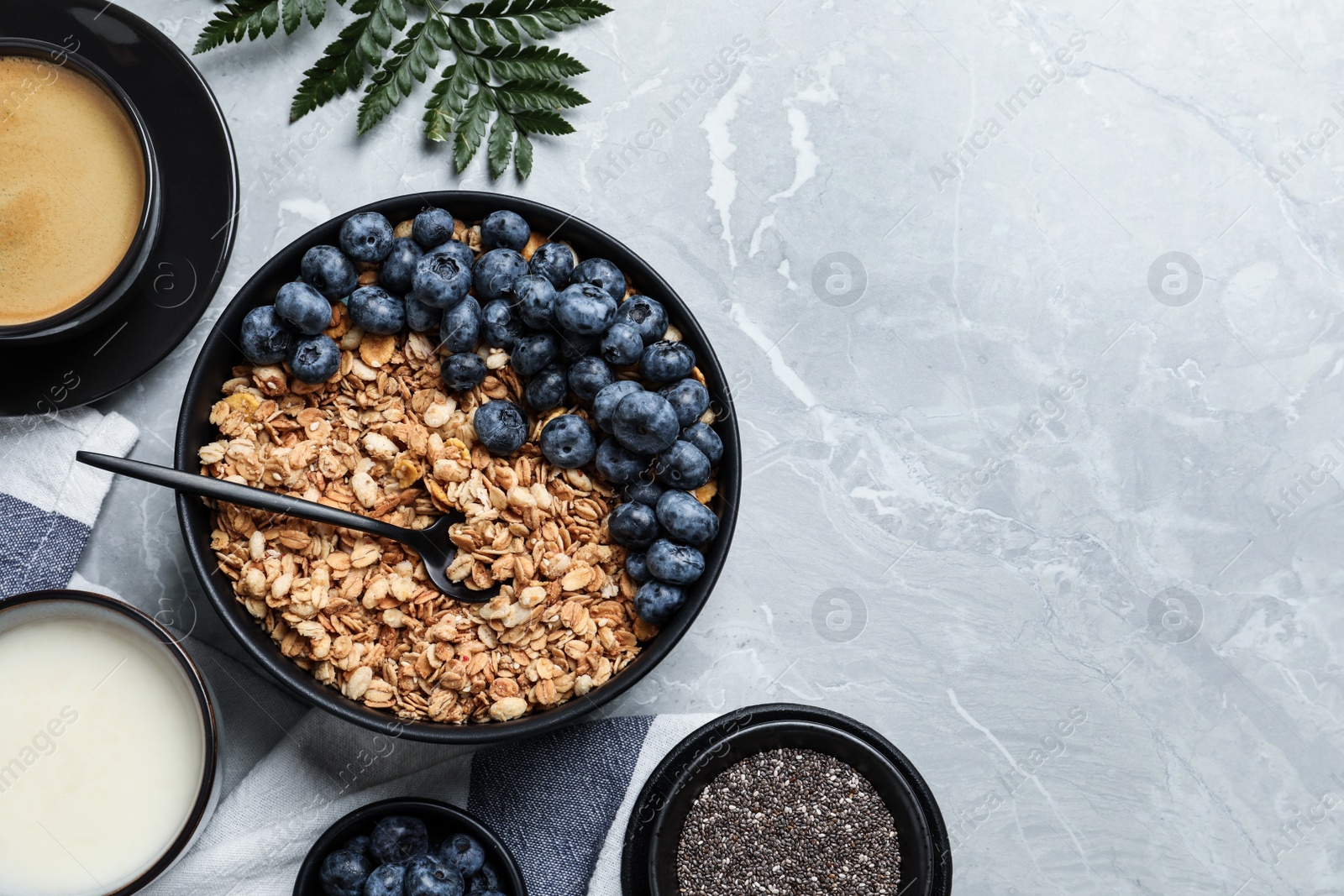 Photo of Bowl of oat with blueberry served on light marble table, flat lay. Space for text