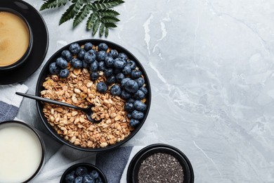 Photo of Bowl of oat with blueberry served on light marble table, flat lay. Space for text