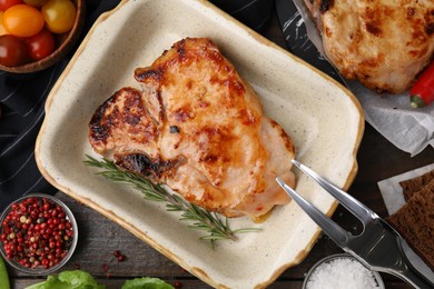 Photo of Tasty marinated meat, rosemary and spices on wooden table, flat lay