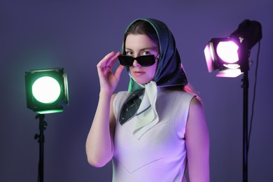 Photo of Portrait of beautiful young woman with sunglasses in photo studio