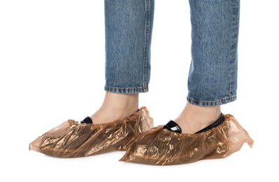 Photo of Woman wearing shoe covers onto her shoes against white background, closeup