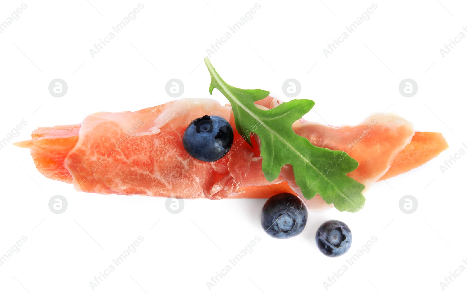 Photo of Slice of fresh melon with prosciutto, blueberries and arugula on white background, top view