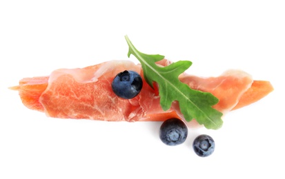 Photo of Slice of fresh melon with prosciutto, blueberries and arugula on white background, top view