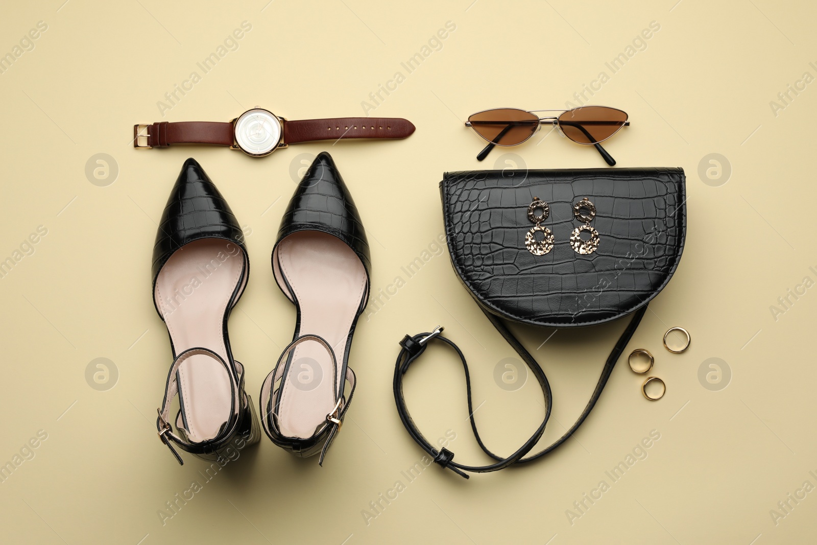 Photo of Stylish woman's bag, shoes and accessories on beige background, flat lay